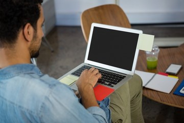 Man working while using laptop in office