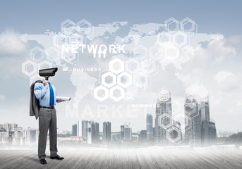 Camera headed man standing on wooden floor against modern cityscape