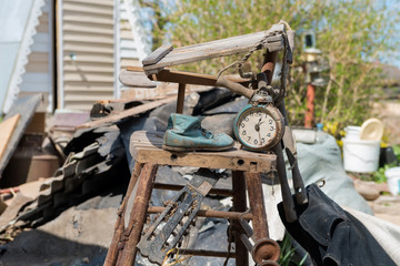 Old watches and a children's boot stand on an old broken highchair