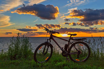 Fototapeta na wymiar Bike by the river in the setting sun. Siberia, Russia