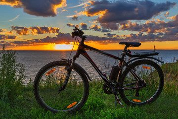 Fototapeta premium Bike by the river in the setting sun. Siberia, Russia
