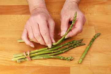 Hands preparing asparagus