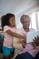 Grandmother and granddaughter using tablet 