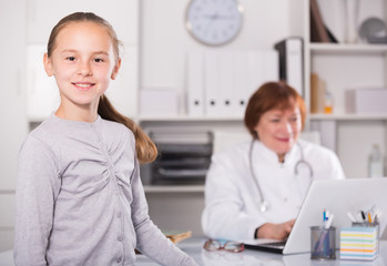 Fototapeta premium Portrait of little child with mature medical worker