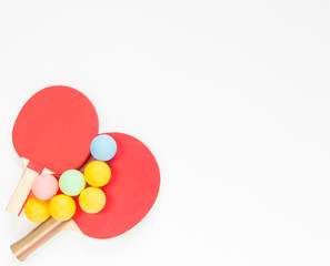 Sport background. Red ping-pong rackets and varicolored balls. Flat lay, top view.