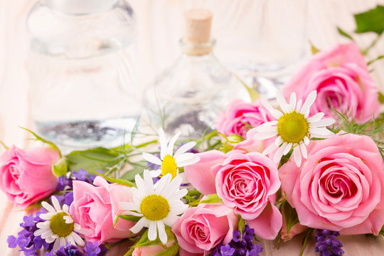 Spa still life - Ätherisches Öl in Glasflasche mit Rosen, Lavendel und Kamille