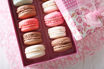 Beautiful food: French macaroons in a gift box close-up on a table. Horizontal top view