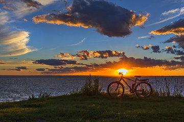 Naklejka na ściany i meble Bike by the river in the setting sun. Siberia, Russia