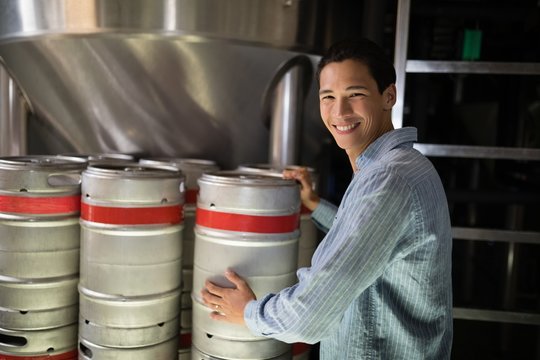 Manager checking beer keg in warehouse