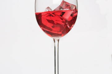 Glass cup with red liquid and ice