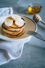 Delicious pancakes with banana and honey on a breakfast