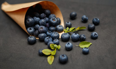 Fresh blueberries with leafs on dark background