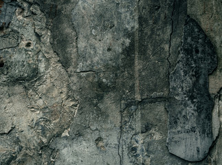Cracked old stone wall background, grunge texture close up.