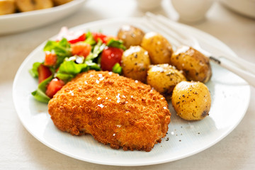 Traditional breaded fillet of cod with baby potatoes and salad 
