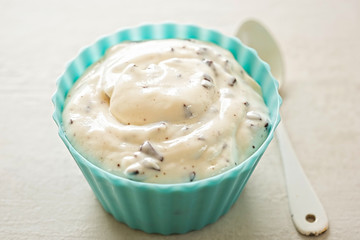 Stracciatella yogurt in small bowl with white spoon