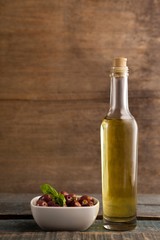 Black olive in container by bottle
