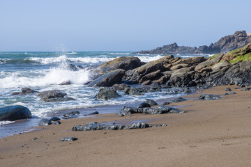 Fototapeta na wymiar Surf and waves on a rocky coast