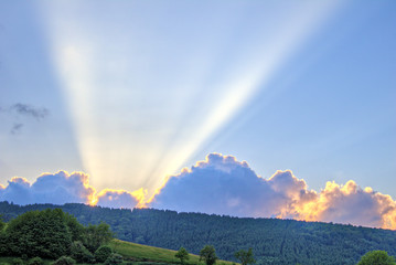 Sunset with rays of light over mountain ridge