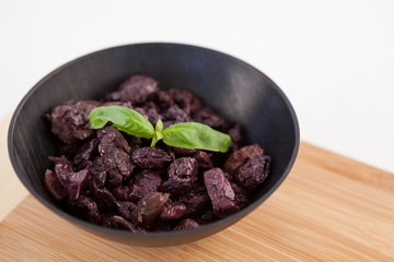 Close up of dried olives in bowl on cutting board