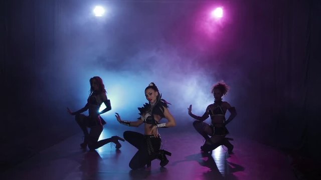 Sexy girls dancing in original leather outfit in lights. Smoky