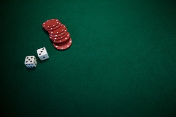 Pair of dice and casino chips on poker table