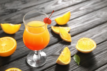 Glass of delicious tequila sunrise cocktail on table
