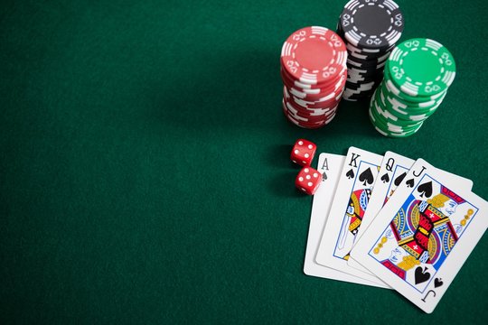 Playing cards, dices and casino chips on poker table