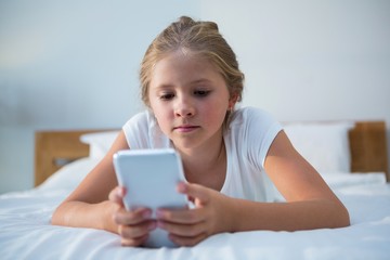 Close up of girl using smartphone on bed