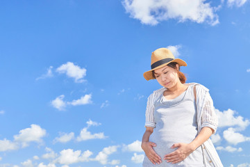 お腹を見つめる妊婦