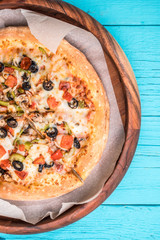 Vegetarian pizza with vegetables on blue table.