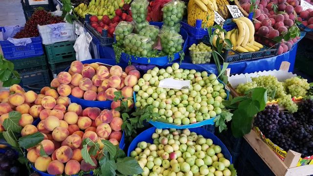 Fresh fruits - peach, damson, plum, apple, grape, pear, banana  - for sale in a market.