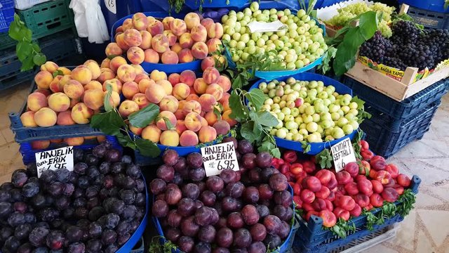 Fresh fruits - peach, damson, plum, apple, grape, pear, banana  - for sale in a market.