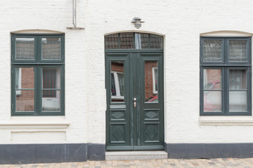 Fototapeta na wymiar Grüne Haustür und grüne Fenster eines Hauses