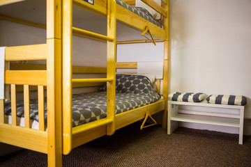 Fototapeta na wymiar Interior of the hostel bedroom. Hostel with wooden bunk beds