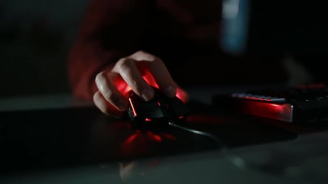 Young man play game using mouse with red light. Closeup shoot of the hand.