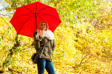 Woman walking in park with umbrella