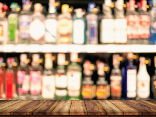 Empty top of wooden table with blurred counter bar and bottles Background.