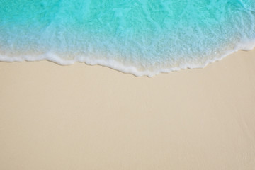 Soft waves of blue sea on the Maldives beach for the background.