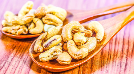 Roasted cashew nuts on a wooden spoon.Roasted salted cashew nuts on white background. Healthy food, cashews rich in heart friendly fatty acids. Cashew nuts as food background.