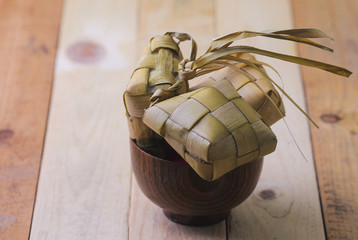 Ketupat (Rice Dumpling) and curry On wooden Background. Ketupat is a natural rice casing made from young coconut leaves for cooking rice during eid Mubarak.