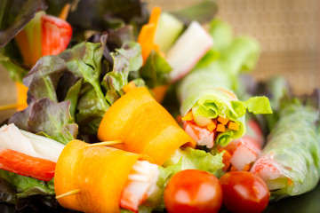 Close up of fresh salad of lettuce, cucumber and tomato on plate for healthy eating...Fresh vegetable salad in Black plate  on wood table. Salad for healthy. Fresh raw vegetables salad background.
