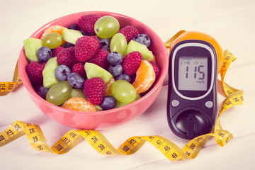 Fresh fruit salad, glucometer and centimeter, diabetes, healthy lifestyle and nutrition concept