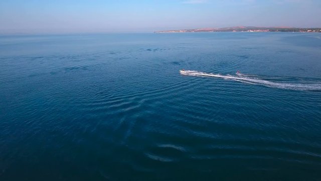 Overflight of wakeboarder and scooter on sea 4K