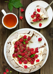 Chocolate dessert (pie) of pavlov with cream and raspberries.