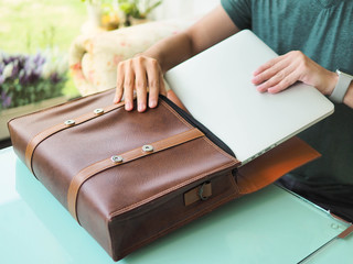 business man pulling laptop into the bag