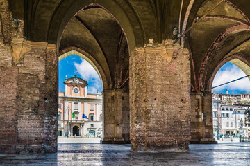 Piacenza, medieval town, Italy. Piazza Cavalli (Square horses) and Palazzo del Governatore  (Governor's palace) from the arcade of palazzo Gotico (Gothic palace) in the city center