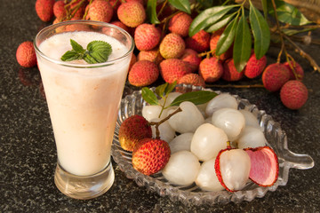 Litchi juice in a glass. Fresh juicy lychee fruit on a glass plate.