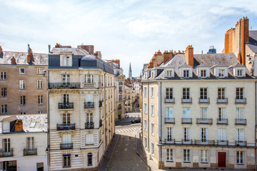 Street view on the beautiful residential buildings andchurch tower in Nantes city during the sunny day in France