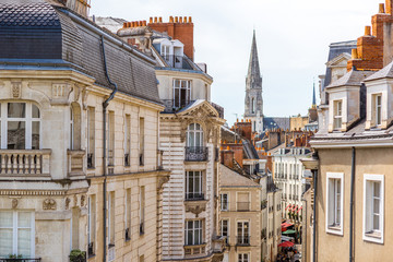 Street view on the beautiful residential buildings andchurch tower in Nantes city during the sunny day in France - obrazy, fototapety, plakaty