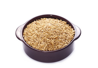 Oat grains in purple porcelain dish, cup isolated on white background